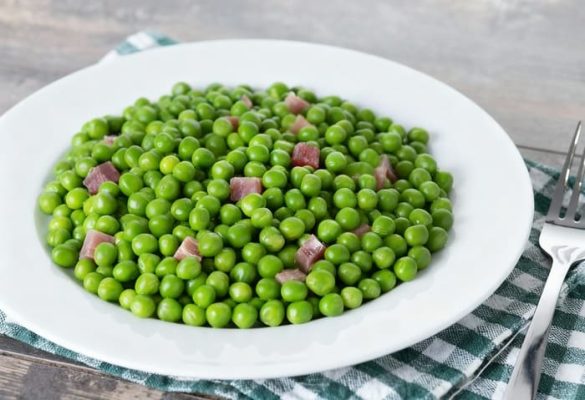 guisantes con jamón servidos en un plato blanco, receta tradicional fácil y saludable